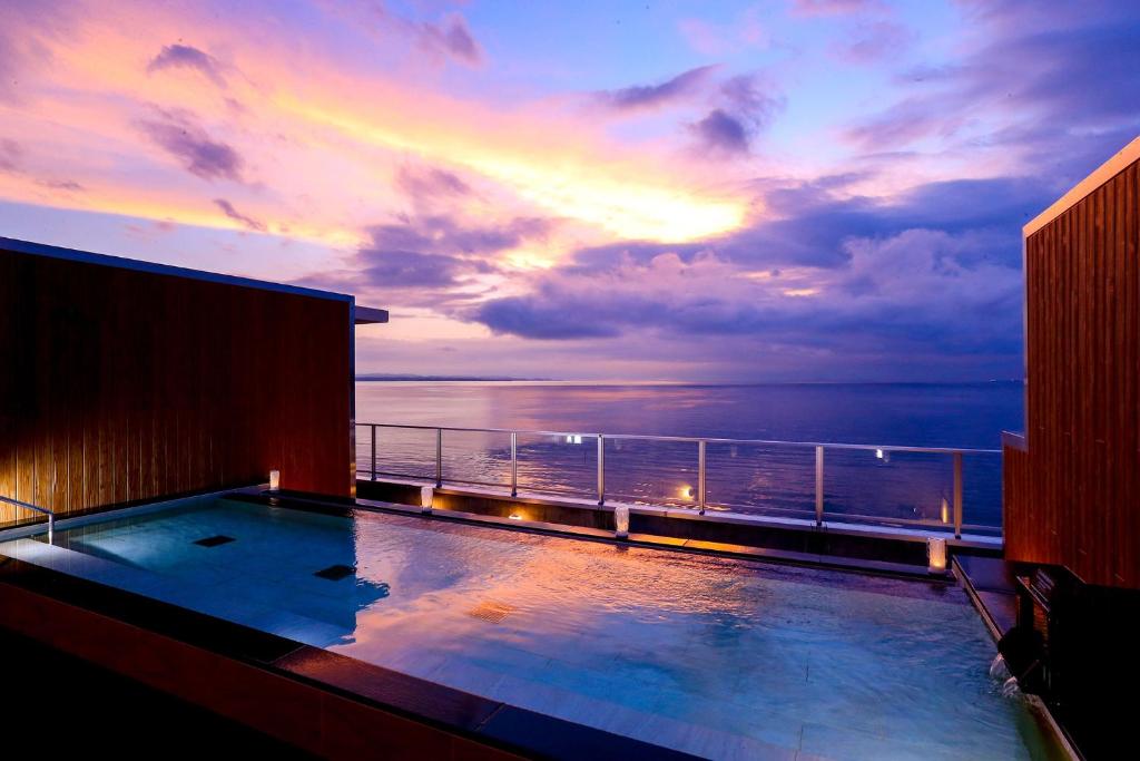 a swimming pool on a cruise ship at sunset at Ooedo Onsen Monogatari Beppu Seifu in Beppu