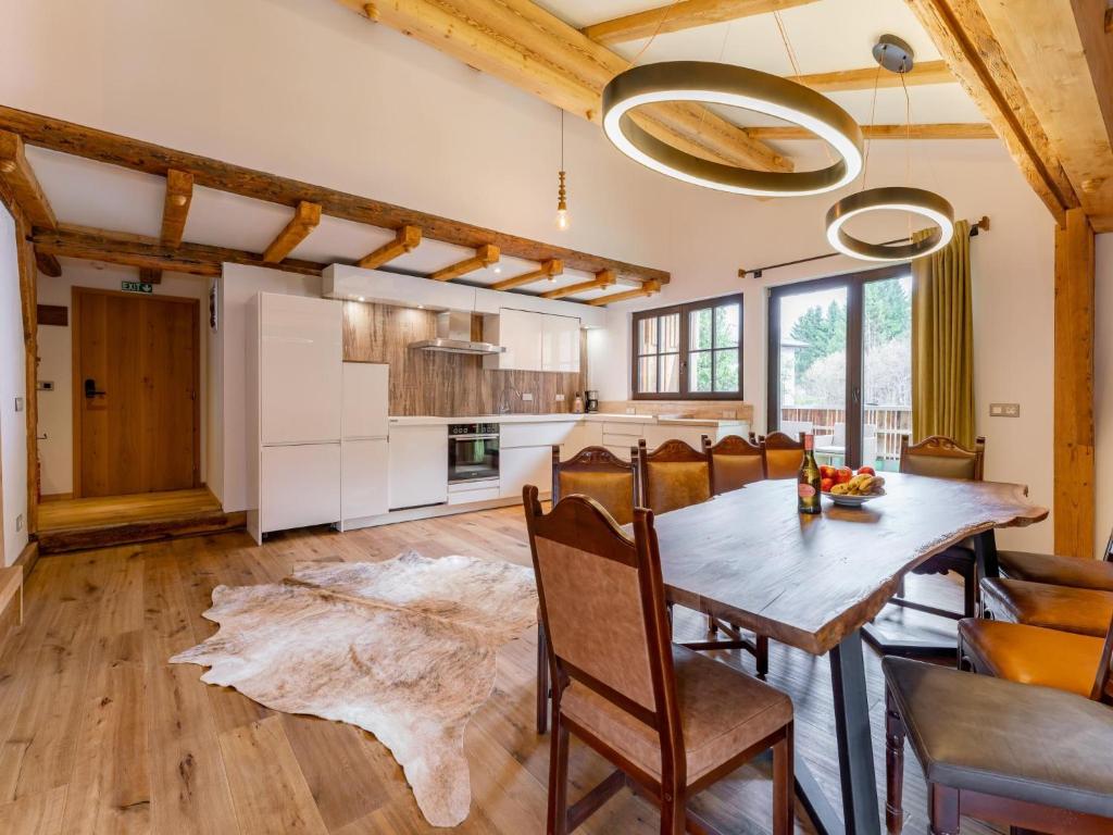 Il comprend une cuisine et une salle à manger avec une table et des chaises en bois. dans l'établissement Biber Art Chalet, à Biberwier