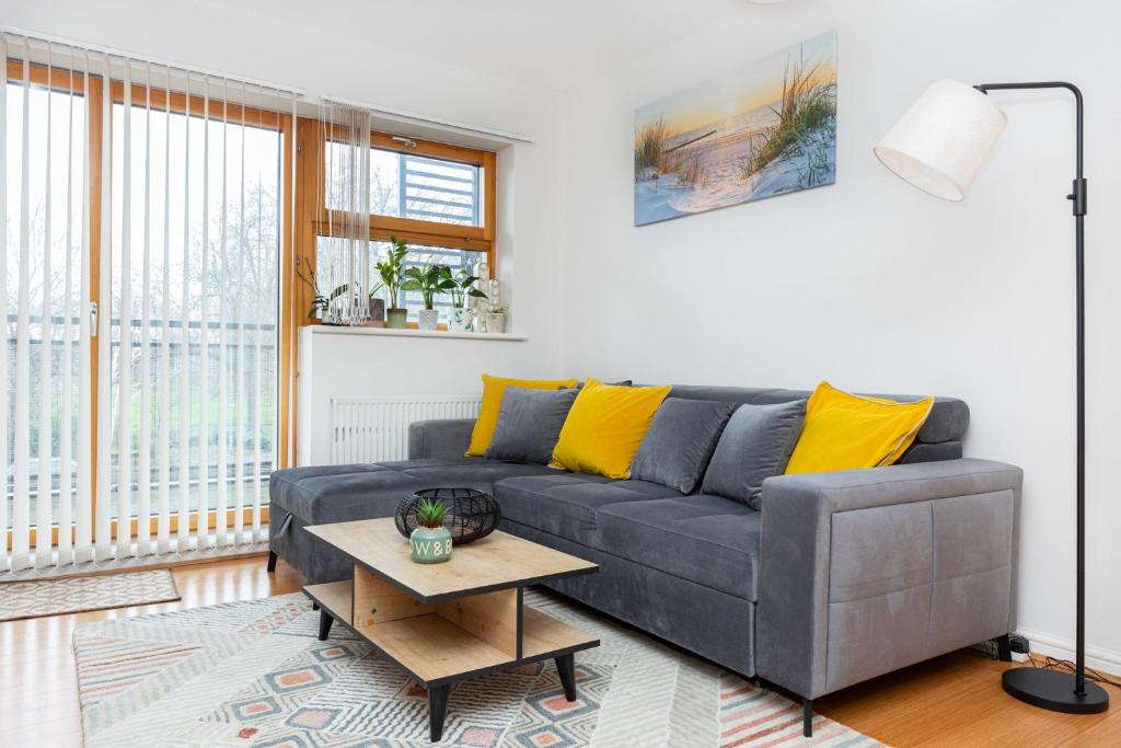 a living room with a gray couch and yellow pillows at Hidden Gem 2BR flat wBalcony near Surrey Quays in London