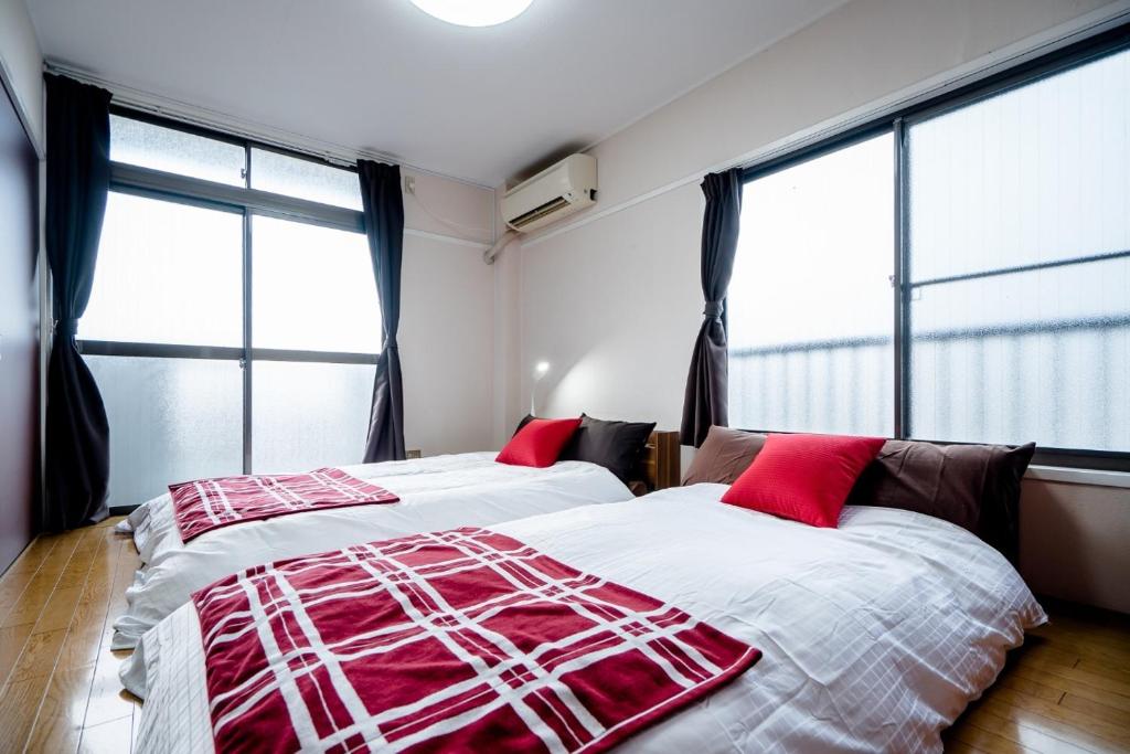 2 letti in una camera da letto con ampie finestre di Murata COPO 305 / Vacation STAY 2893 a Tokyo