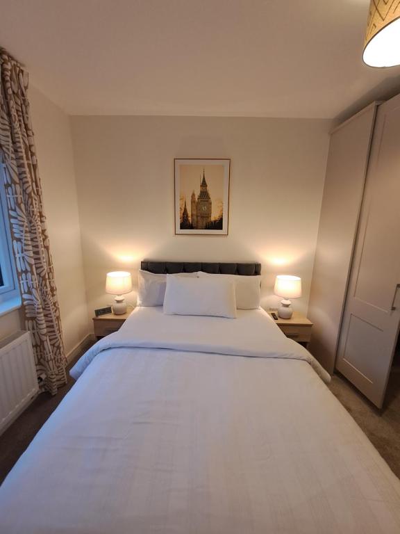 - une chambre avec un grand lit blanc et deux lampes dans l'établissement Cozy bedroom in Lucan, Dublin, à Dublin