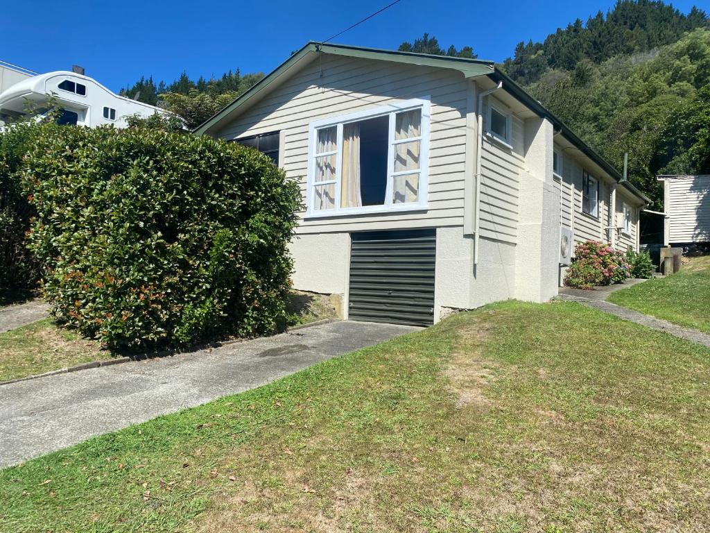 una casa blanca con garaje en un patio en Peaceful Picton Home en Picton