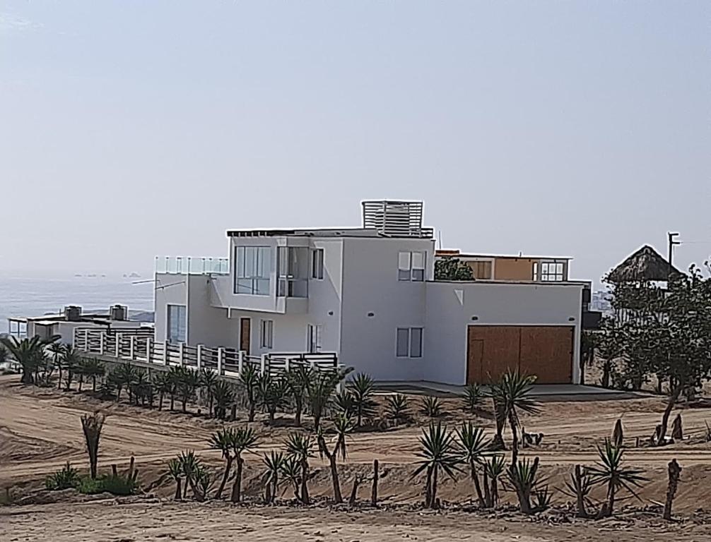 une maison sur la plage avec des palmiers devant elle dans l'établissement CASA DE PLAYA Todo el año, à Punta Negra