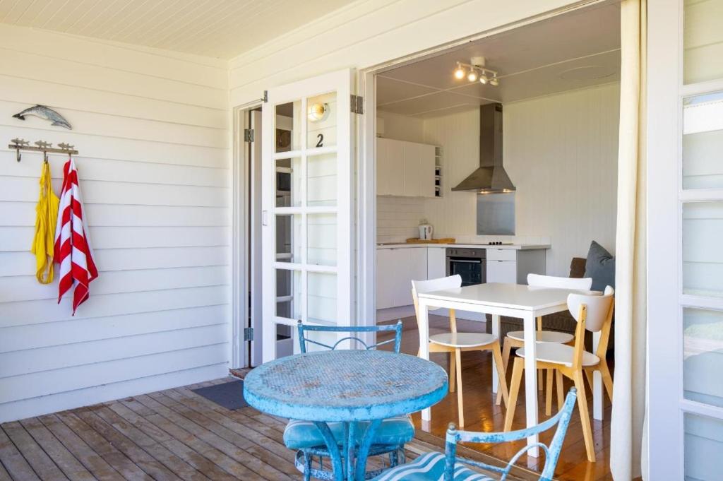 a porch with a table and chairs and a kitchen at Sorrento Beach Cottages No. 2 - in the heart of Sorrento in Sorrento