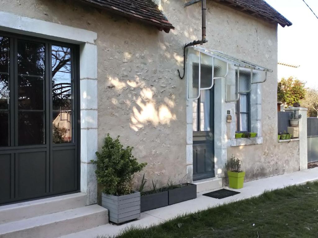 una casa con una puerta negra y ventanas en Gîte Communauté de communes Brenne - Val de Creuse-Ciron, 2 pièces, 4 personnes - FR-1-591-21, en Ciron