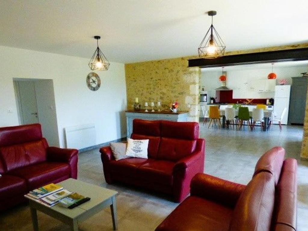 a living room with two red chairs and a table at Gîte Le Bernard, 6 pièces, 10 personnes - FR-1-426-164 in Le Bernard