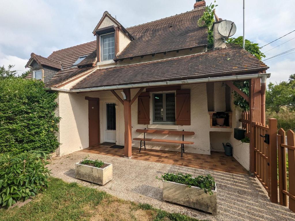 una casa con un banco en un patio en Gîte Communauté de communes Brenne - Val de Creuse-Rosnay, 3 pièces, 5 personnes - FR-1-591-80, en Rosnay