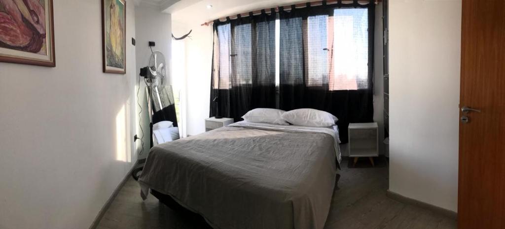 um pequeno quarto com uma cama e uma janela em Habitación privada, La Plata em La Plata
