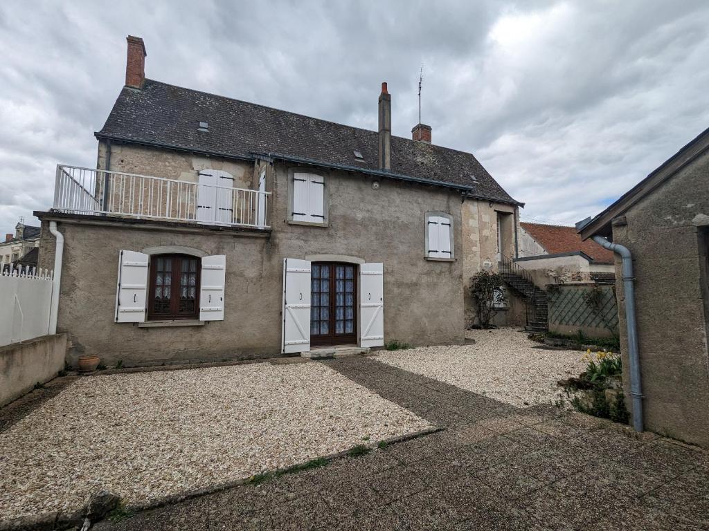 Casa de ladrillo antigua con ventanas blancas y balcón. en Gîte Mézières-en-Brenne, 3 pièces, 5 personnes - FR-1-591-229, en Mézières-en-Brenne