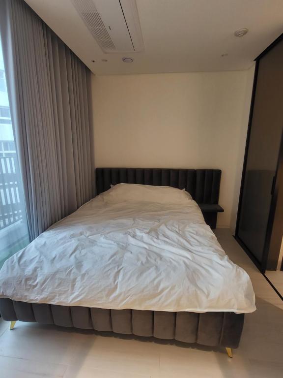 a large bed in a room with a large window at Domus in Seoul