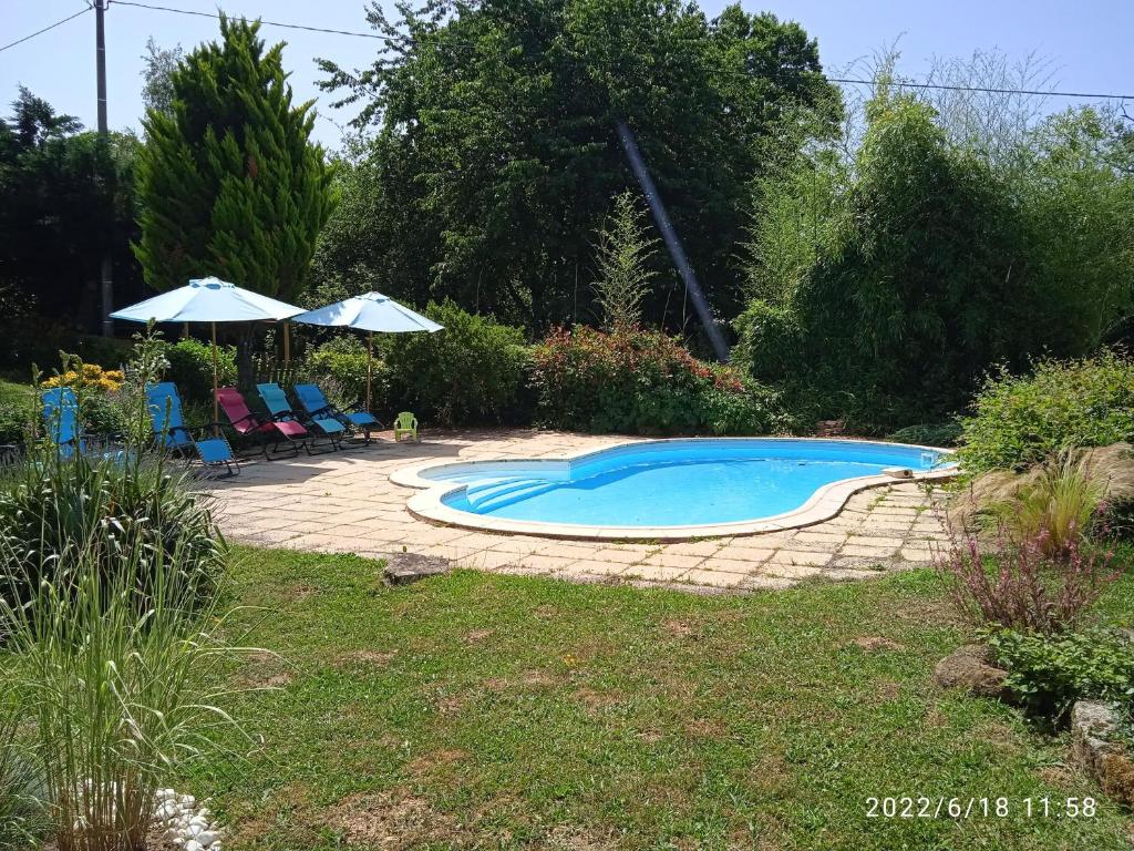 einen Pool mit Stühlen und Sonnenschirmen im Hof in der Unterkunft Gîte Vigoulant, 5 pièces, 11 personnes - FR-1-591-333 in Vigoulant