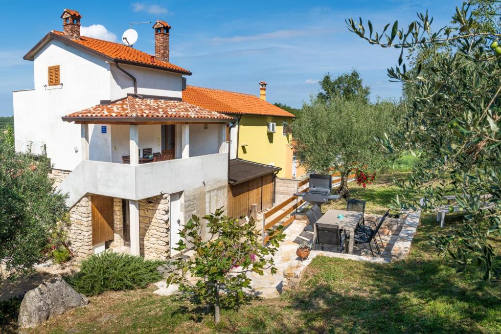 ein kleines gelbes und weißes Haus in einem Garten in der Unterkunft Apartments with a parking space Gornji Picudo, Umag - 22354 in Umag