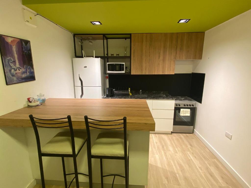 a kitchen with a counter with three chairs around it at Andén 7 3/5 in Salta