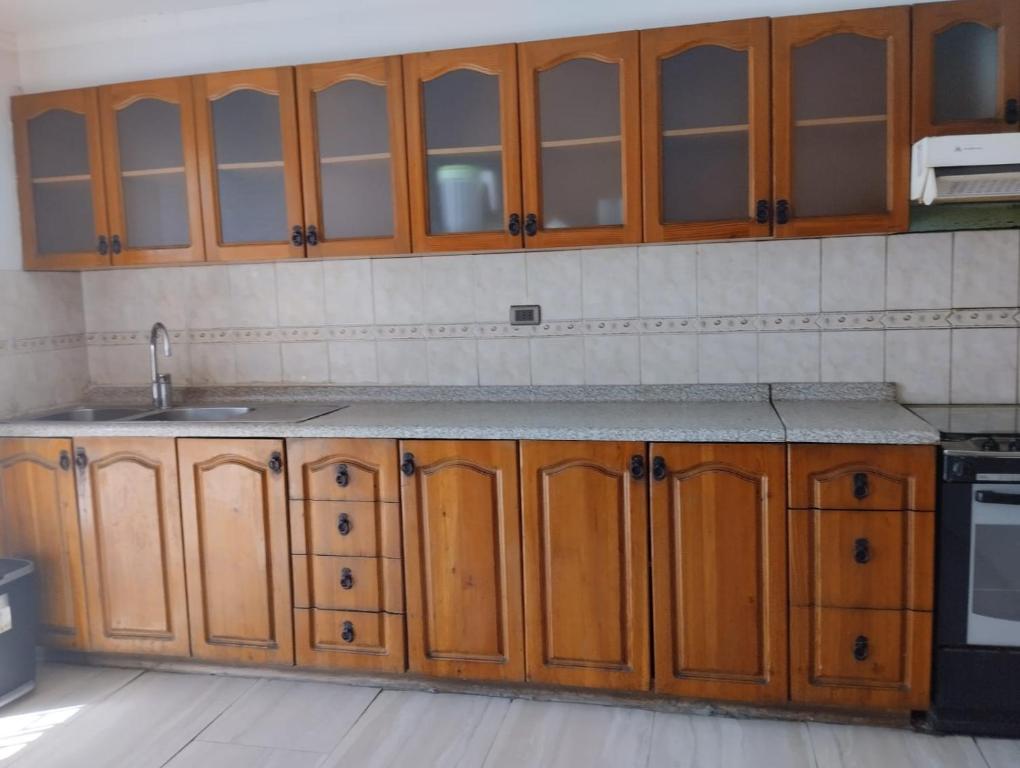 una cocina con armarios de madera y fregadero en Amatista house, en Copiapó