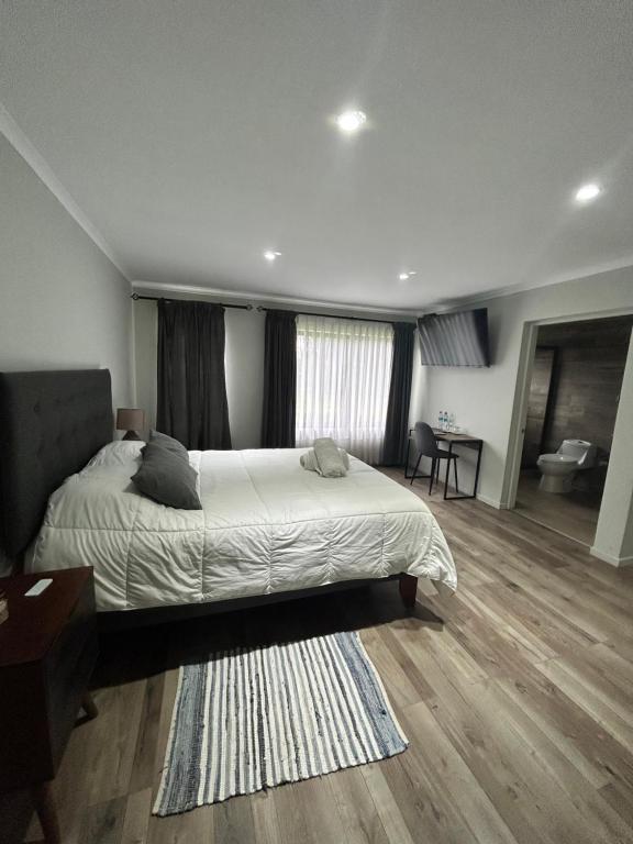 1 dormitorio con 1 cama grande y sala de estar en La casona Talpen, en Constitución