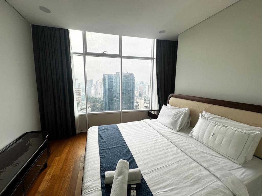 a hotel room with a bed with a large window at Sky Suites KL City Center in Kuala Lumpur