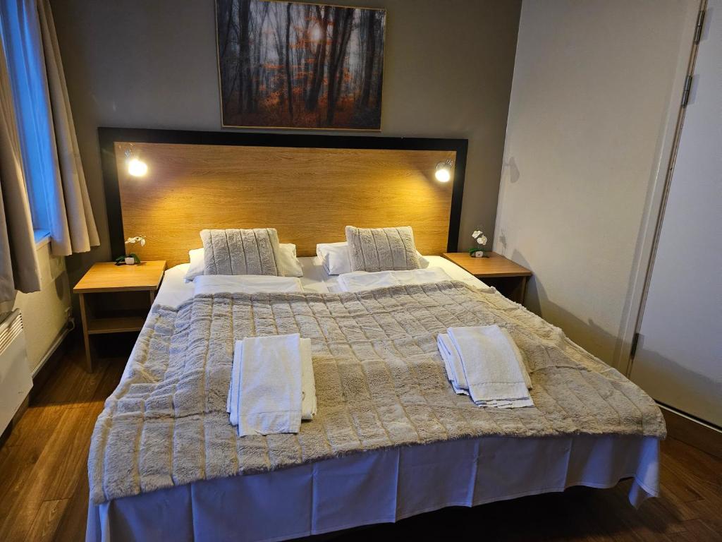 a bedroom with a large bed with two towels on it at Motell Lier in Lier