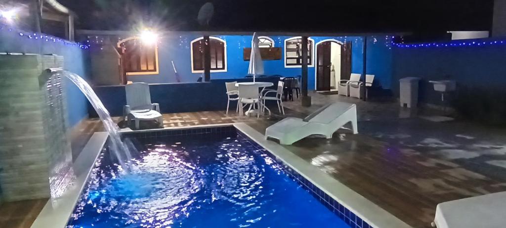 una piscina con una fuente de agua en una casa en Casa OliMar fins de semana, en Bertioga