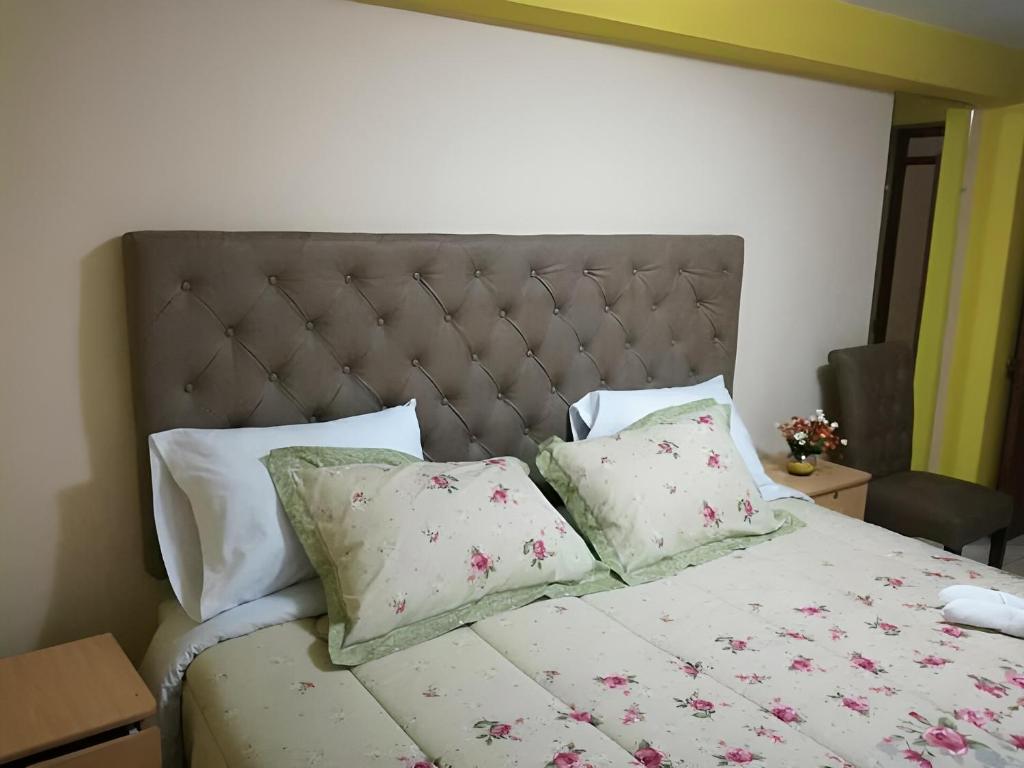Un dormitorio con una cama con flores rosas. en hotel Ramos, en Arequipa