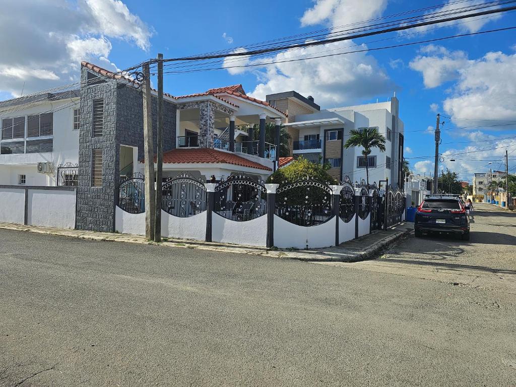 una cerca blanca frente a una casa en Jlp en San Francisco de Macorís