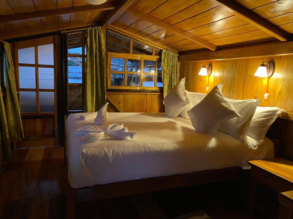 Postel nebo postele na pokoji v ubytování Guayabo Hostal Mindo