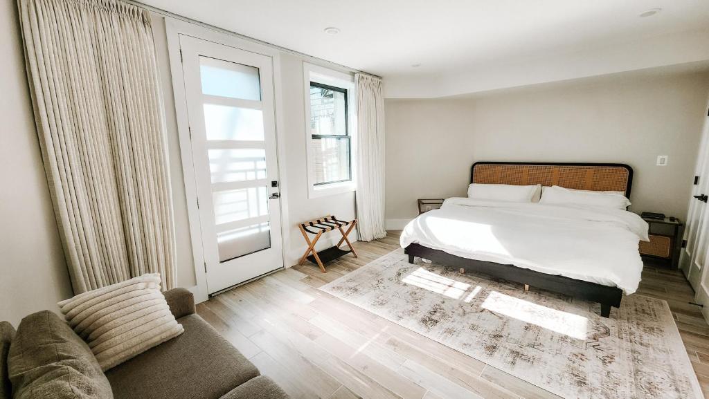 a bedroom with a bed and a couch and a window at Private Modern Luxury Suite in Historic Stone Home in Washington, D.C.