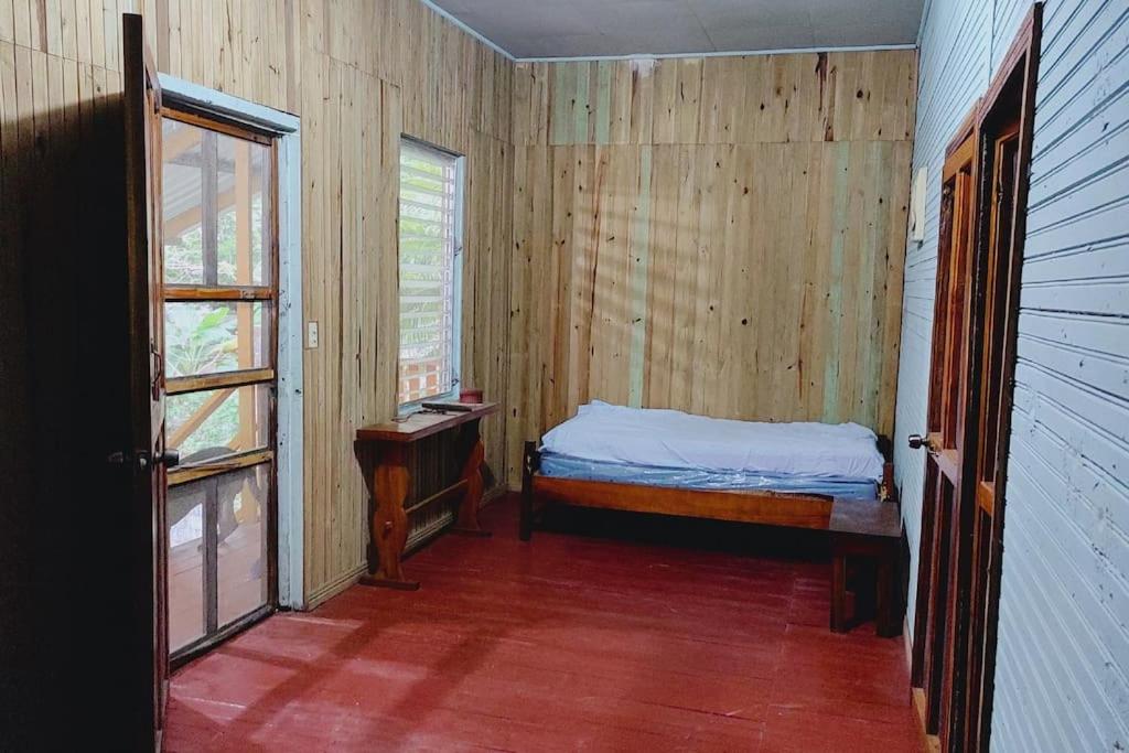 a small bedroom with a bed and a window at Perla del rio tulian in Omoa