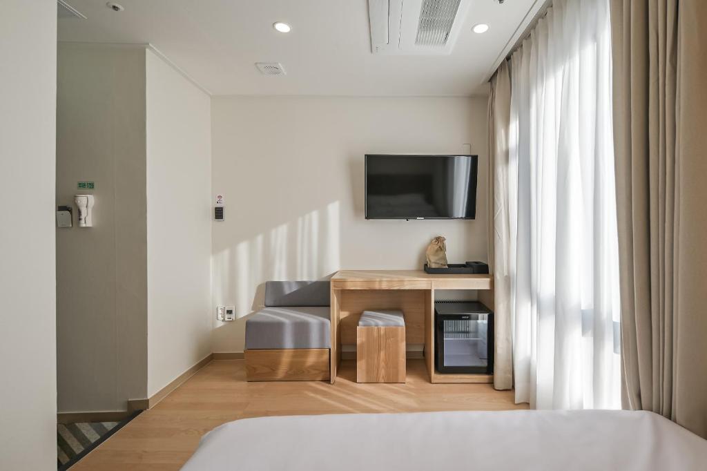 a hotel room with a bed and a tv on the wall at Seoul N Hostel in Seoul