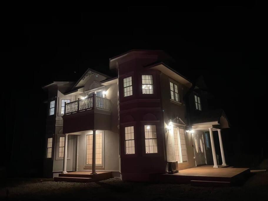 a large house at night with its lights on at Queen Anne Style Luxury Vacation Villa in Miyota