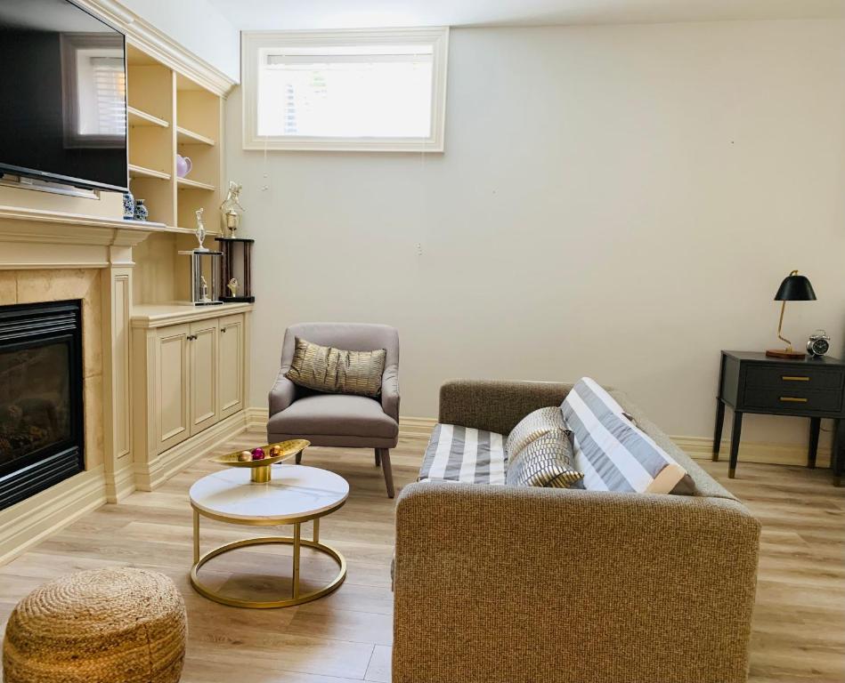 - un salon avec un canapé et une chaise dans l'établissement Stylish Private Suite with 2 Bedrooms in Midtown, à Toronto