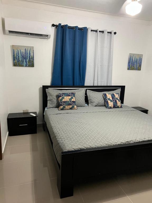 a bedroom with a bed with a blue curtain at Arcus hospedaje in Juan López