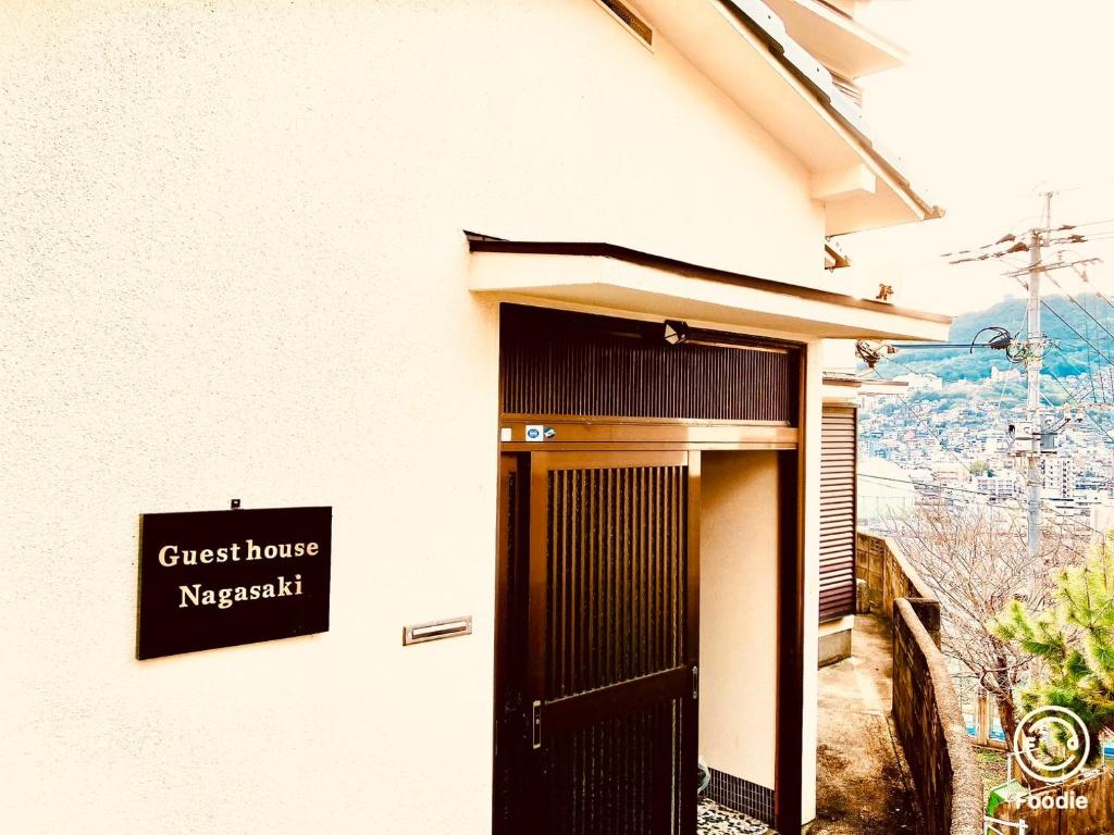 ein Kappachi-Schild der Pension an der Seite eines Gebäudes in der Unterkunft Guest House Nagasaki 2 御船蔵の我が家 2 in Nagasaki