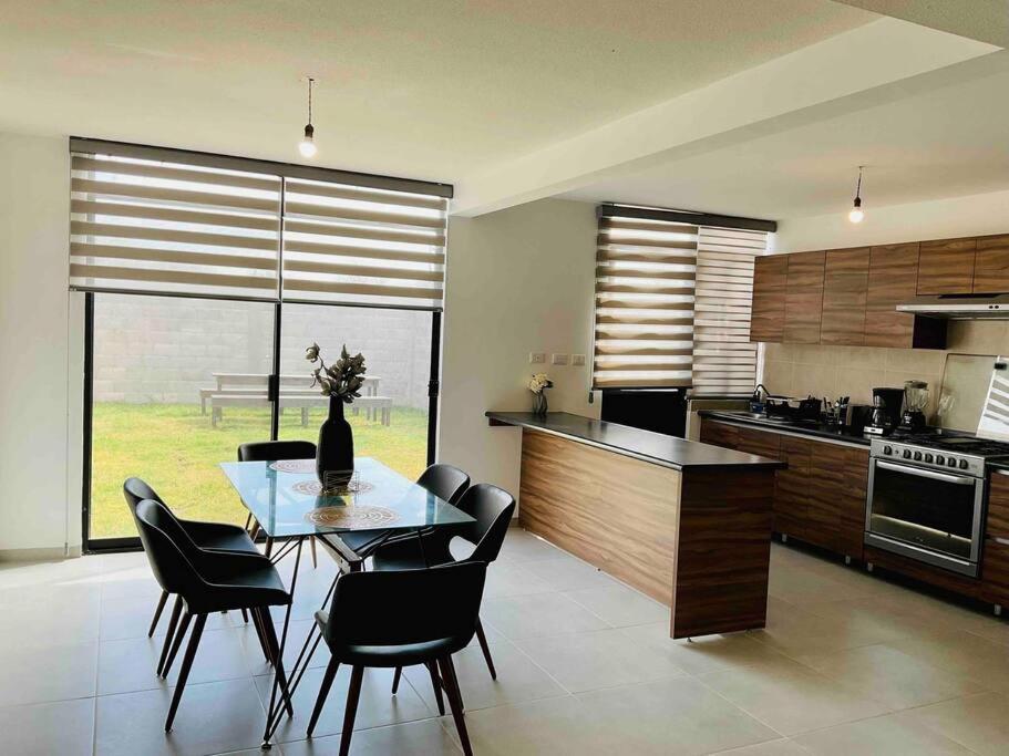 a kitchen with a glass table and black chairs at Espaciosa casa cerca de zona industrial in San Luis Potosí