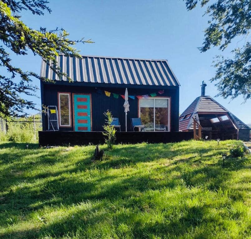 a tiny house with a tin roof on a hill at Tiny Fuy in Puerto Fuy