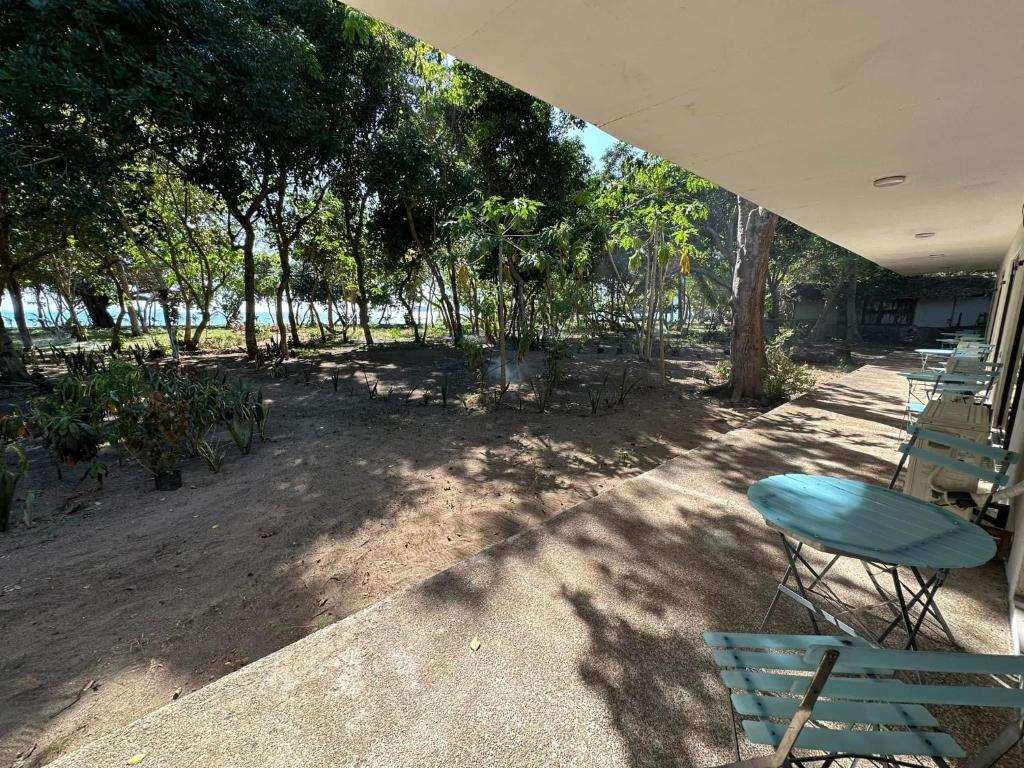 un patio con mesa, sillas y árboles en Magalong Villa at Holy Land in Busuanga, en Busuanga