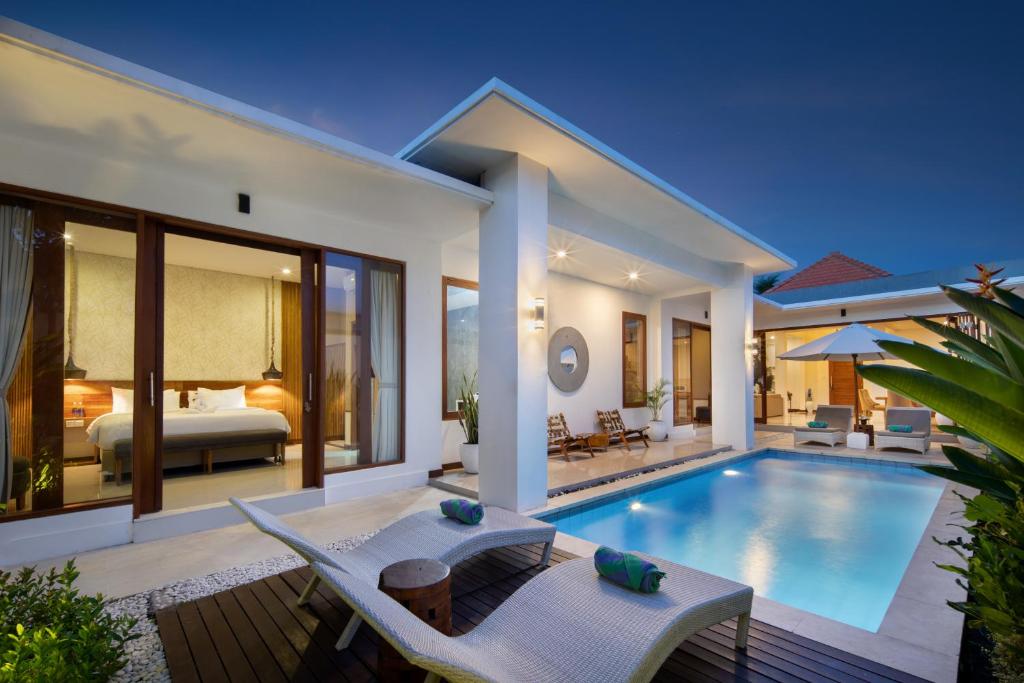 a villa with a swimming pool and a bedroom at The Luxury Collection, Monaco Blu in Seminyak