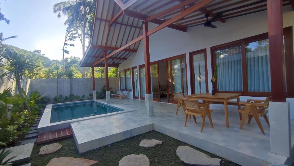 クタにあるKaryana Villa 1のプール、テーブル、椅子付