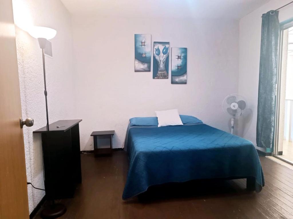1 dormitorio con 1 cama con manta azul en HOSTAL ROMA, en Ciudad de México