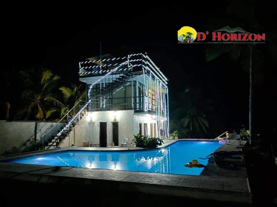 un edificio con piscina por la noche en DONQUE'S MOUNTAIN RESORT (D'HORIZON), en Samboan