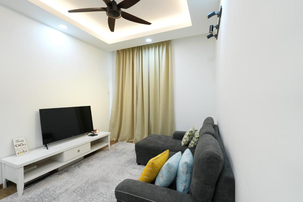 uma sala de estar com um sofá e uma televisão de ecrã plano em Flat in Cyberjaya ~ 5 mins to Tamarind Square em Cyberjaya