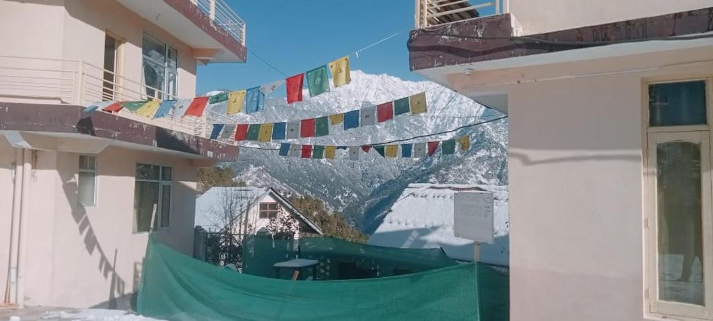 a group of flags hanging from a building with a mountain at Neo Himalyan stays in Dharamshala