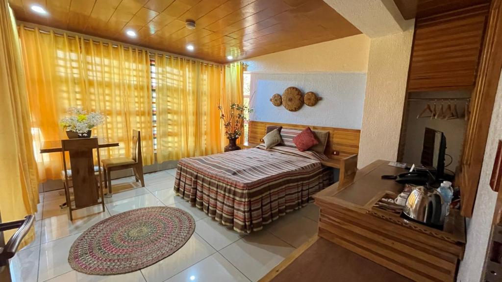 CITI HOTEL في Hilongos: غرفة نوم بسرير وطاولة في غرفة