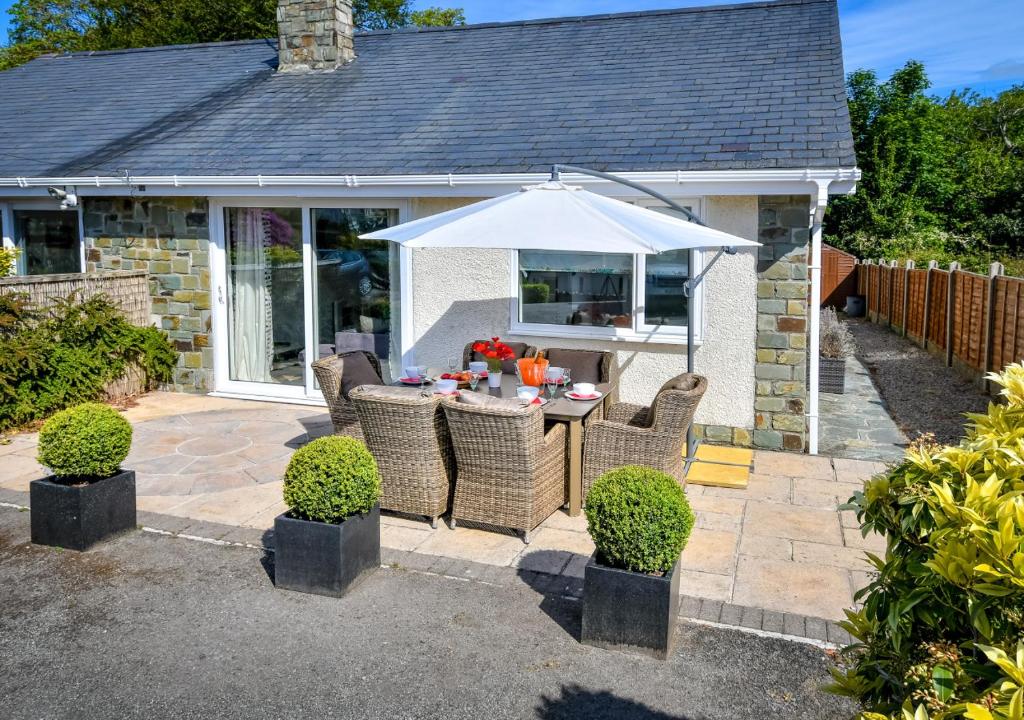 a patio with a table and an umbrella at Hillview in Llanbedrog