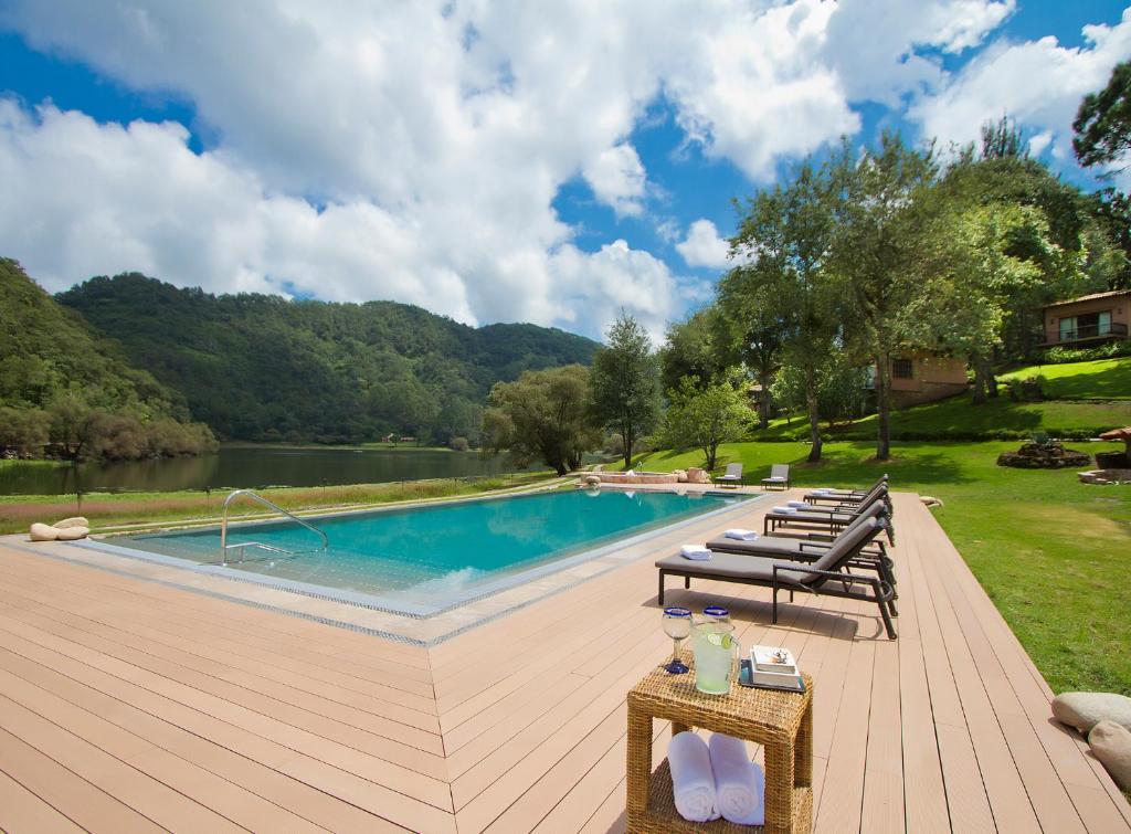 una piscina con tumbonas y una terraza de madera en Sierra Lago, en La Laguna