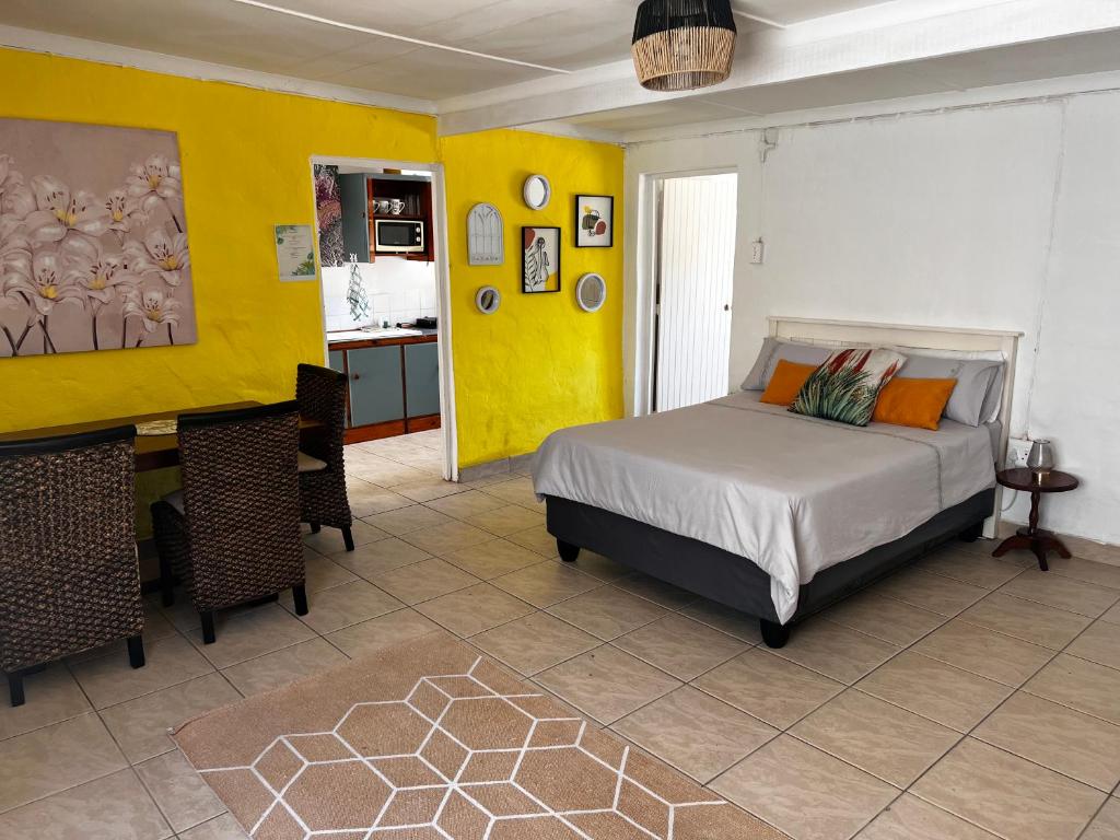 sypialnia z łóżkiem i żółtą ścianą w obiekcie The Calvert w mieście Fort Beaufort