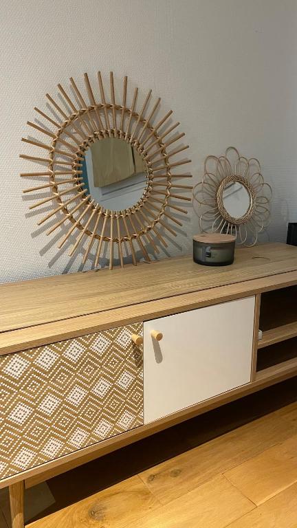 un miroir assis au-dessus d'une commode en bois dans l'établissement Appartement Vasil - proche de Paris, à Villemomble