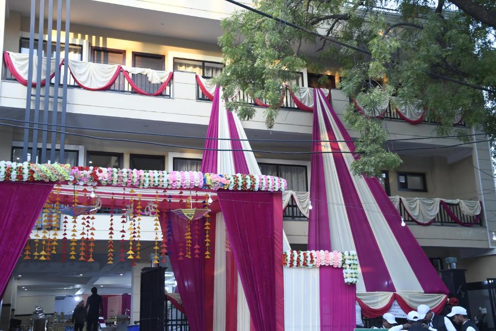 dois guarda-chuvas vermelhos e brancos em frente a um edifício em NIRMAL HOMES em Faridabad