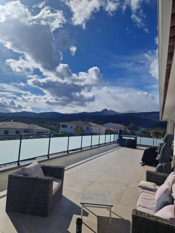 un balcon avec des chaises et une vue sur les montagnes dans l'établissement VILLA entre mer, montagnes, étangs et rivières, à Ventiseri