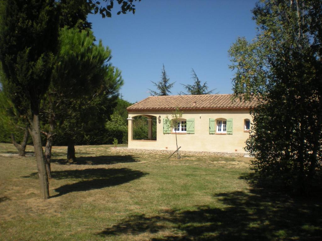 a small house in a yard with trees at Gites De La Grasse in Carcassonne