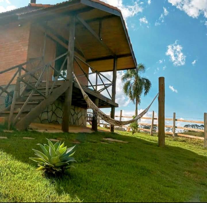 budynek z hamakiem w trawie obok plaży w obiekcie Chalet di Alta Montagna w mieście Santo Antônio do Pinhal